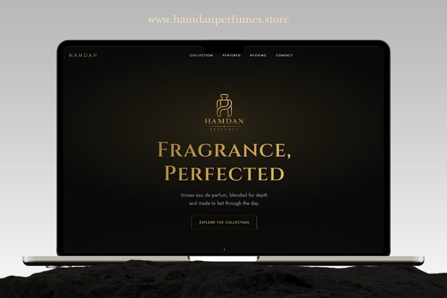 Hamdan Perfumes open on a laptop: a black and gold home page with the brand's bottle mark, the heading 'Fragrance, Perfected', a line about unisex eau de parfum, and an Explore the Collection button, under the address hamdanperfumes.store.